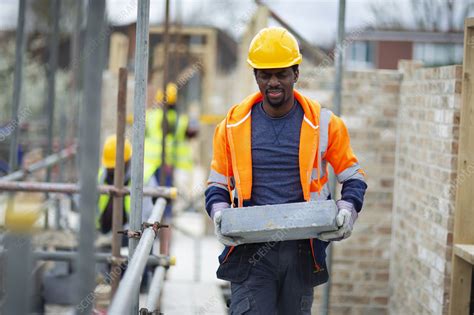 Construction Worker Carrying Brick At Construction Site Stock Image