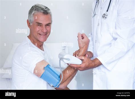 Doctor Checking Senior Mans Blood Pressure Stock Photo Alamy