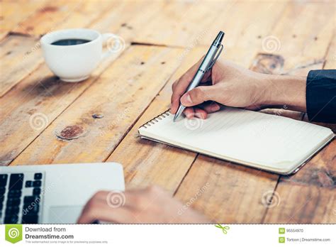 Hand Business Man Writing Notebook On Wood Table In Coffee Shop Stock