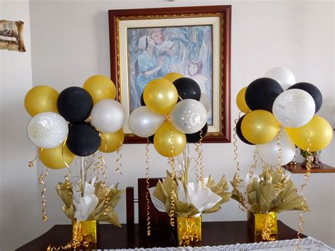 Balloons And Streamers Are In Vases On A Table With Gold White And