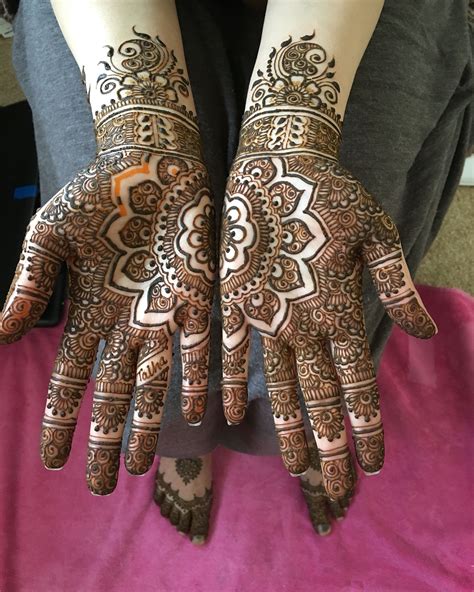 The Hands Are Decorated With Henna Designs