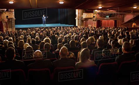 Audience watching performer on stage in theater - Stock Photo - Dissolve