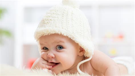 Cute Baby Child Is Having Fingers Inside Mouth Wearing Woolen Knitted
