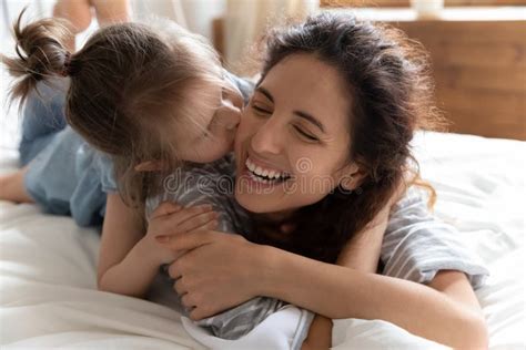 Daughter Kisses Mother Cheek Lying Together In Bed Feels Happy Stock Image Image Of Concept