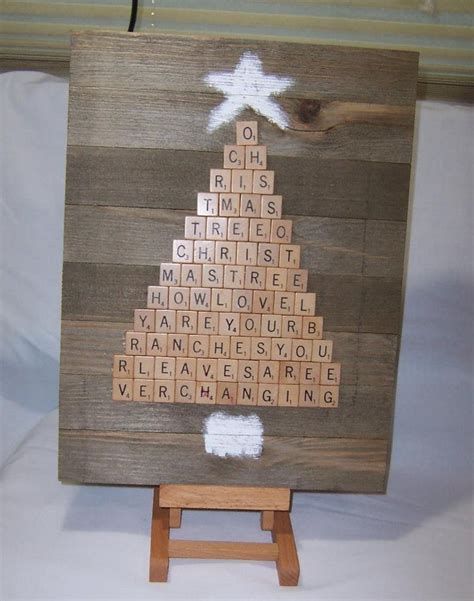 A Christmas Tree Made Out Of Scrabbles On A Wooden Easel With White Paint