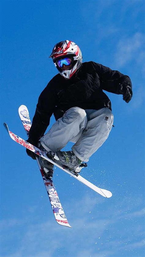 A Man Flying Through The Air While Riding Skis