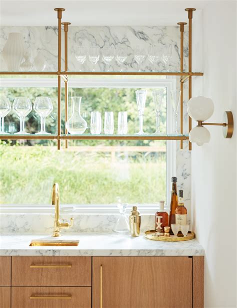 For our kitchen, we wanted to keep the gap that's on. Open ceiling mounted glass and brass shelving in window ...