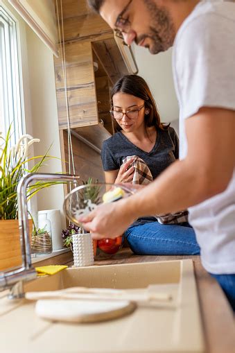 Couple Washing And Wiping The Dishes In The Kitchen Stock Photo