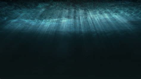 Deep Blue Underwater With Sunlight Rays Shining Through Ocean Surface