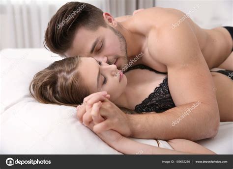 Sexy jeune couple en sous vêtements couché sur le lit à la maison image libre de droit par