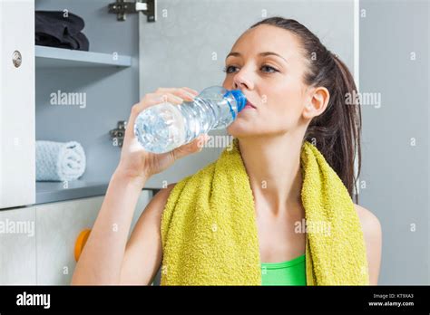Girl Drinking Water In Locker Room After Fitness Training Stock Photo