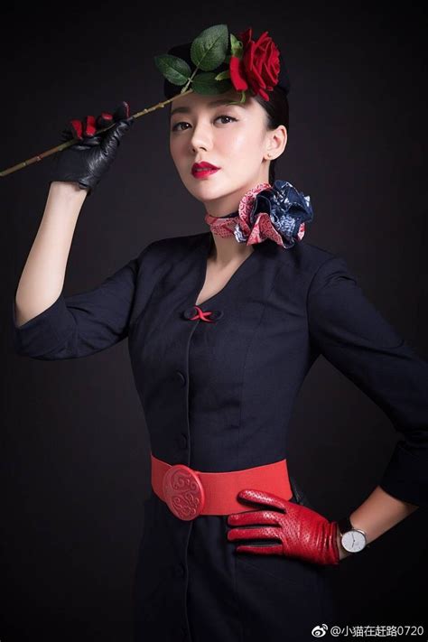 A Woman In Black Dress And Red Gloves Holding A Rose On Top Of Her Head