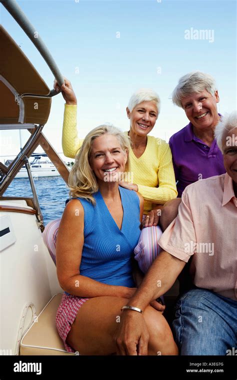 Portrait Of Two Mature Couples Sitting In A Boat And Smiling Together