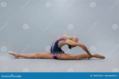 Beautiful Flexible Gymnast In Sports Outfit Performs An Element Of Rhythmic Gymnastics Stock