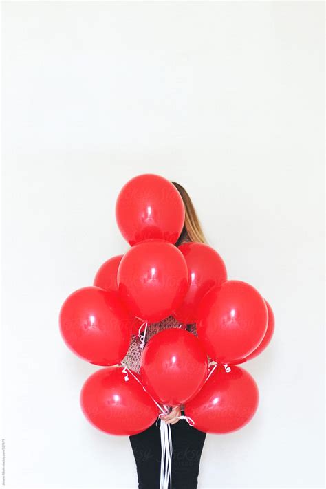 Woman Holding Bunch Of Red Balloons Del Colaborador De Stocksy