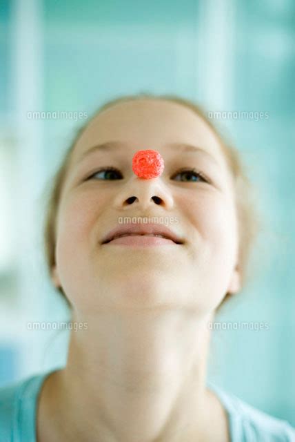 Girl Balancing Piece Of Sugary Cereal 11001031538 の写真素材・イラスト素材｜アマナイメージズ