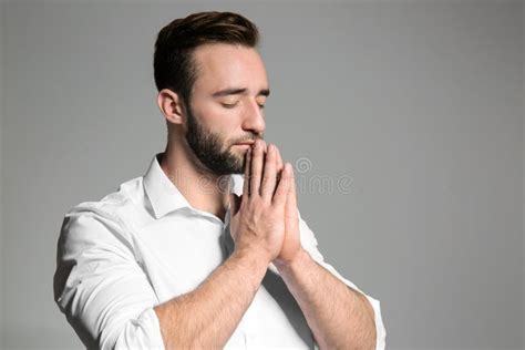 Religious Young Man Praying To God On Light Background Stock Image