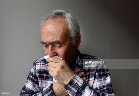 Older Man Coughing Into Napkin High Res Stock Photo Getty Images