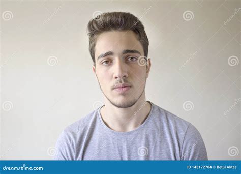 Portrait Of Young Handsome Man Looking At Camera Isolated On Gray