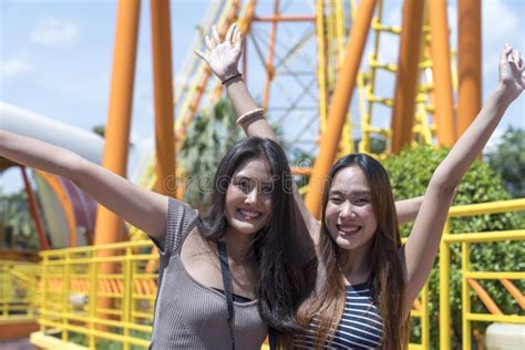 Teenage Girls Traveling In An Amusement Park Two Female Are Taking