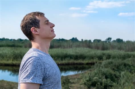 Premium Photo Relaxed Adult Man Breathing Fresh Air Outdoors With Lake And Field In The Background
