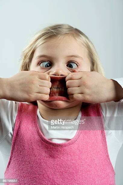 Girl With Her Fingers In Her Mouth Making A Face Foto E Immagini Stock Getty Images