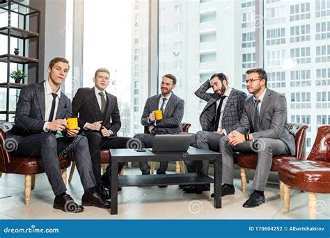 Group Of Business Men Have Active Discussion In Modern Office Stock