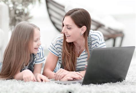 Mom And Her Little Daughter Using A Laptop In Their Free Time Stock