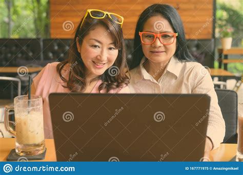 Two Mature Asian Women Together Hanging Out At The Coffee Shop Stock
