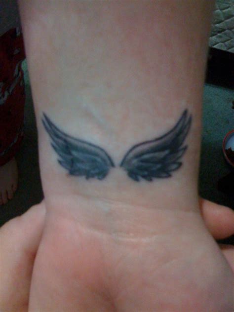 Fancy angel wings tattoo on wrist. 28 Elegant Angel Wings Tattoos On Wrists