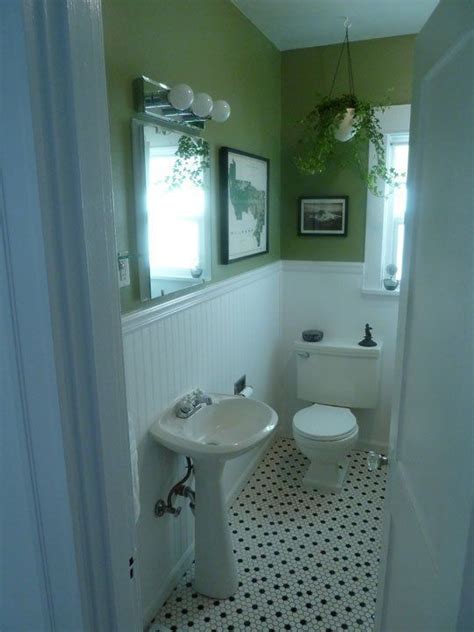 A white beadboard bath vanity sits in a light blue bathroom and is accented with a gray marble countertop fitted beneath a round pivot mirror mounted to a light gray wall lit by flower sconces. green + white beadboard in 2020 | Small bathroom renos ...