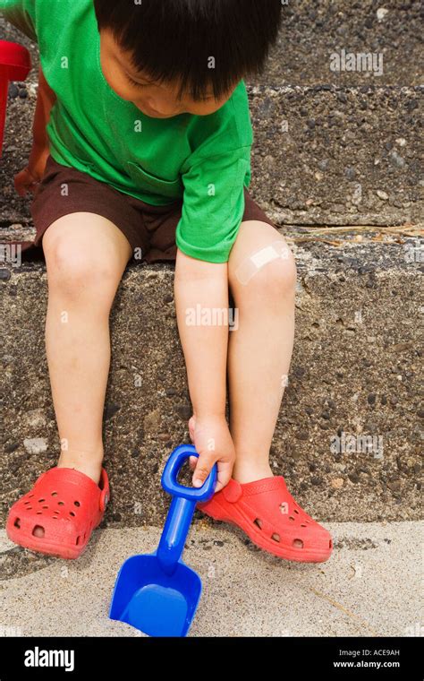Young Boy Digging In The Sand Stock Photo Alamy