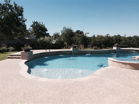 Freeform Travertine Pool With Raised Beam Wall Firepit Traditional
