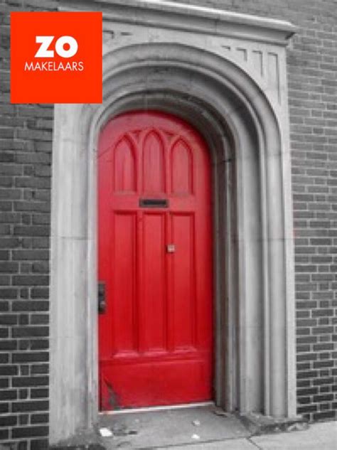 A Red Door Is On The Side Of A Brick Building With An Arch Above It