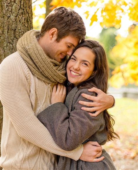Sonriente pareja abrazándose en el parque otoño Fotos de Stock Syda