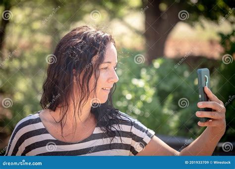 Selective Focus Shot Of An Attractive Caucasian Female Taking A Selfie In The Garden Stock Image