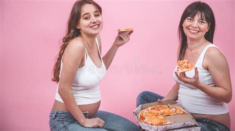Nutrition Concept Pregnant Women Eating Pizza On A Pink Background 库存