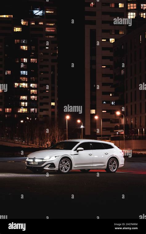 Vertical Shot Of A Volkswagen Arteon In A Moody City At Night Stock