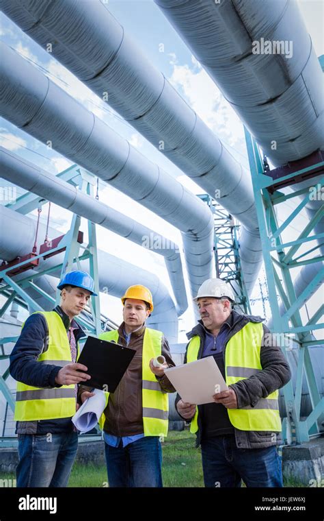 Engineers Discussing Maintenance Of A Petrochemical Plant Technical