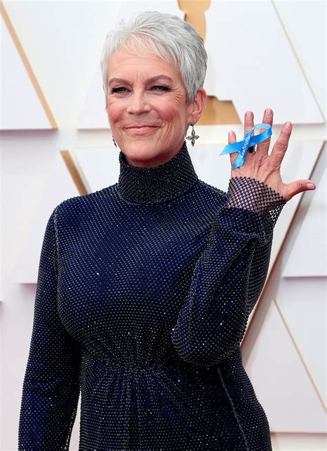 An Older Woman With Grey Hair Wearing A Blue Dress And Holding Her Hand