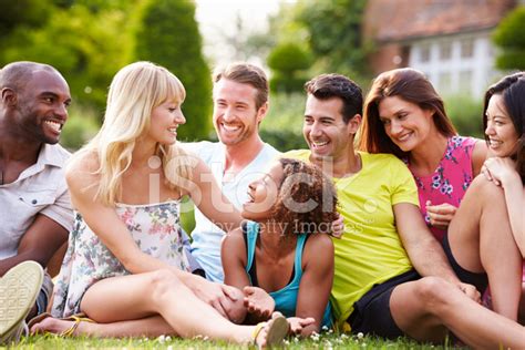 Group Of Friends Sitting On Grass Together Stock Photo Royalty Free