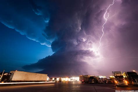 A Lightning Storm Is Seen Over Trucks On The Road