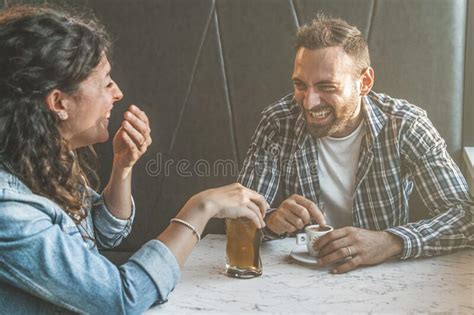 Engaged Couple Laughs And Jokes In A Bar Friends Have Fun While Having A Drink In A Coffee Bar