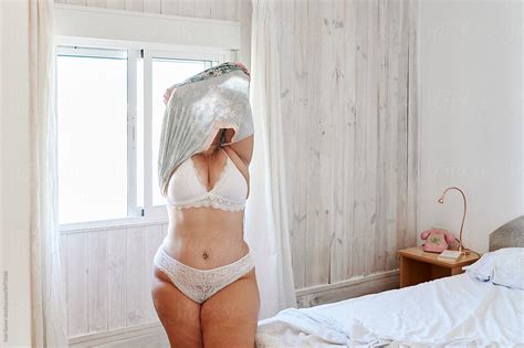 Full Figured Woman Undressing In Her Bedroom By Stocksy Contributor