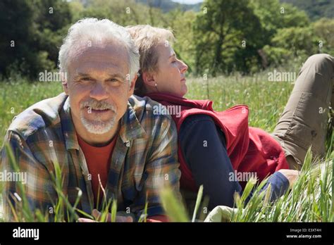 Senior Caucasian Couple Relaxing In Tall Grass Stock Photo Alamy