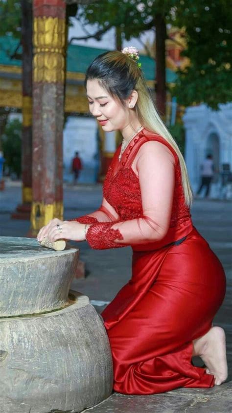 A Woman In A Red Dress Kneeling Down Next To A Water Fountain With Her