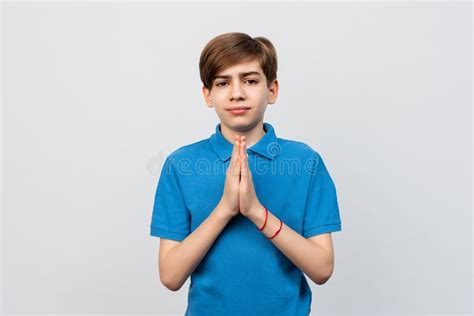 Hopeful Teen Boy Praying With Hands Held Together Waiting For Results