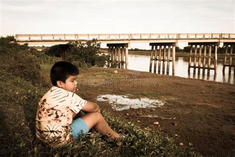 Little Boy Sitting Alone At River Stock Photo Image Of Cloudy