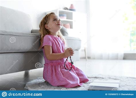 Cute Little Girl With Beads Praying In Living Room Stock Photo Image