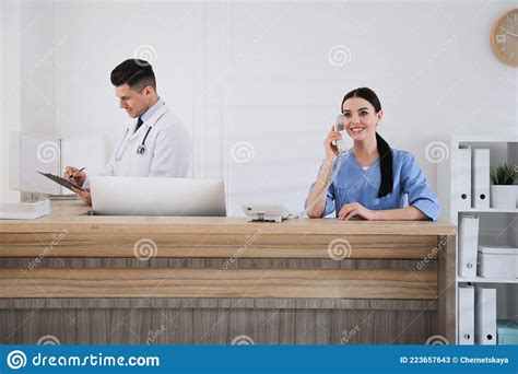 Receptionist And Doctor Working At Countertop Stock Image Image Of